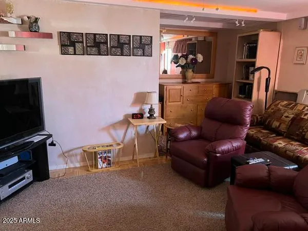 a living room with furniture a flat screen tv and gym equipment