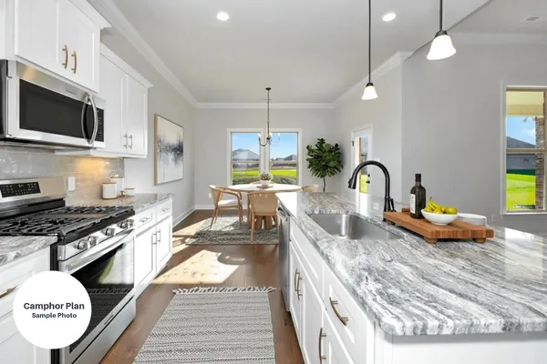 a kitchen with stainless steel appliances granite countertop a stove a sink and a microwave