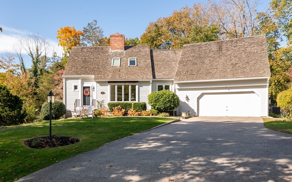 a front view of a house with a yard and trees