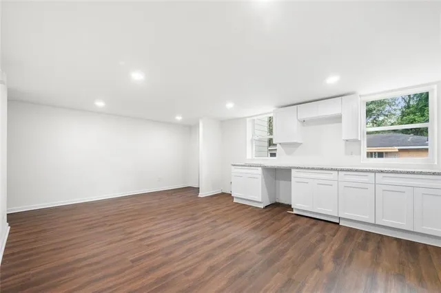 a large white kitchen with a white wooden cabinets and white appliances