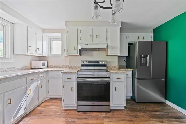 a kitchen with cabinets stainless steel appliances and a counter space