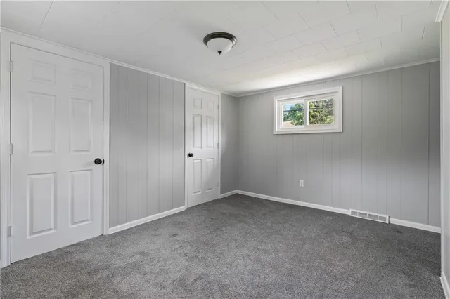 a view of an empty room with closet and a window