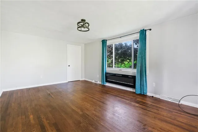 a view of a room with wooden floor and window