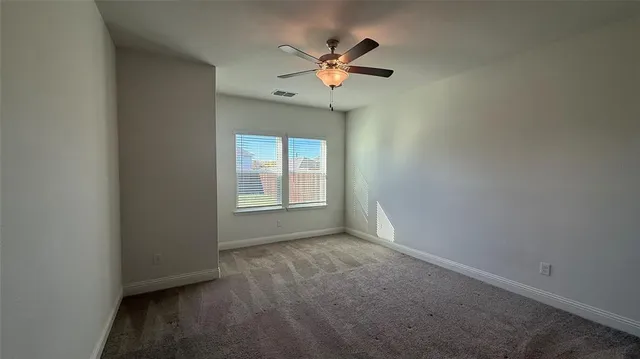 an empty room with a window and a fan