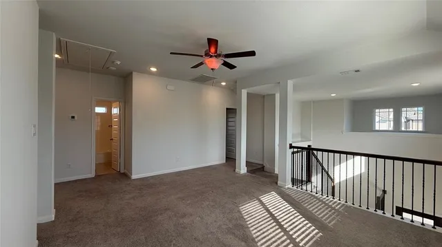 a view of a hallway with a ceiling fan