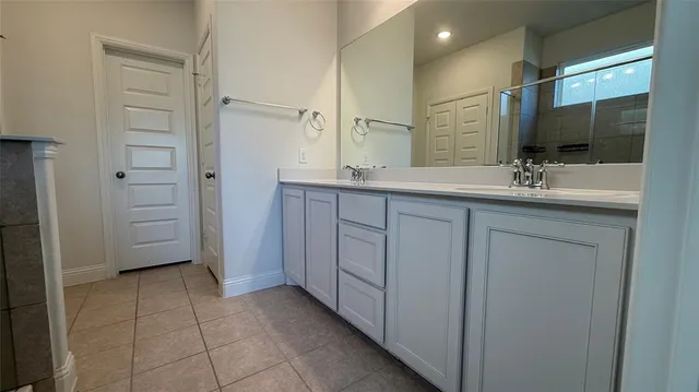 a bathroom with a double vanity sink a mirror and a bathtub