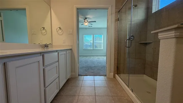 a bathroom with a granite countertop sink a mirror and a shower