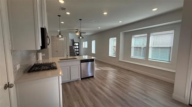 a kitchen with a refrigerator and a stove top oven