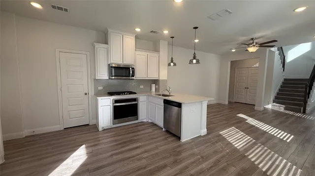 a kitchen with a refrigerator and a stove top oven