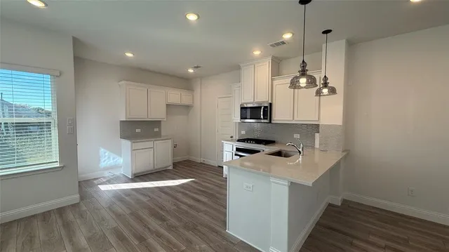 a kitchen with stove cabinets and wooden floor