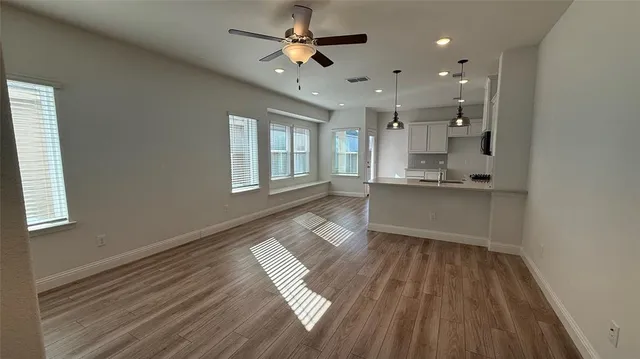 a view of a kitchen with wooden floor and a window