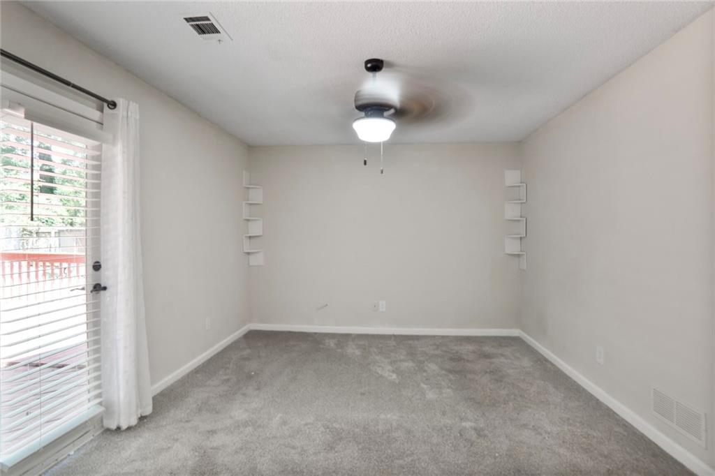 3756 Old Oak Court Powder Springs, GA 30127 - Photo 2 of 14 an empty room with a window and ceiling fan