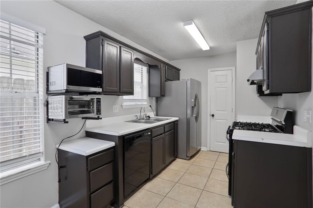 3756 Old Oak Court Powder Springs, GA 30127 - Photo 3 of 14 a kitchen with a stove a sink and a refrigerator