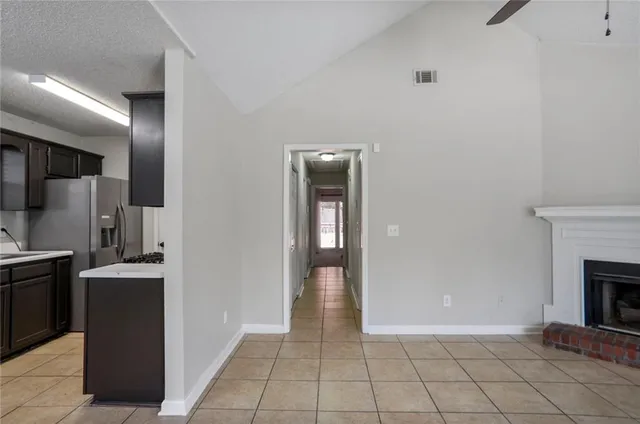 a view of a kitchen from the hallway with a fireplace