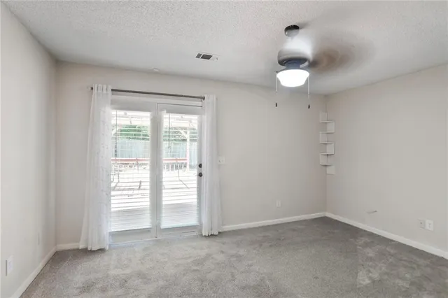 an empty room with a window and a kitchen