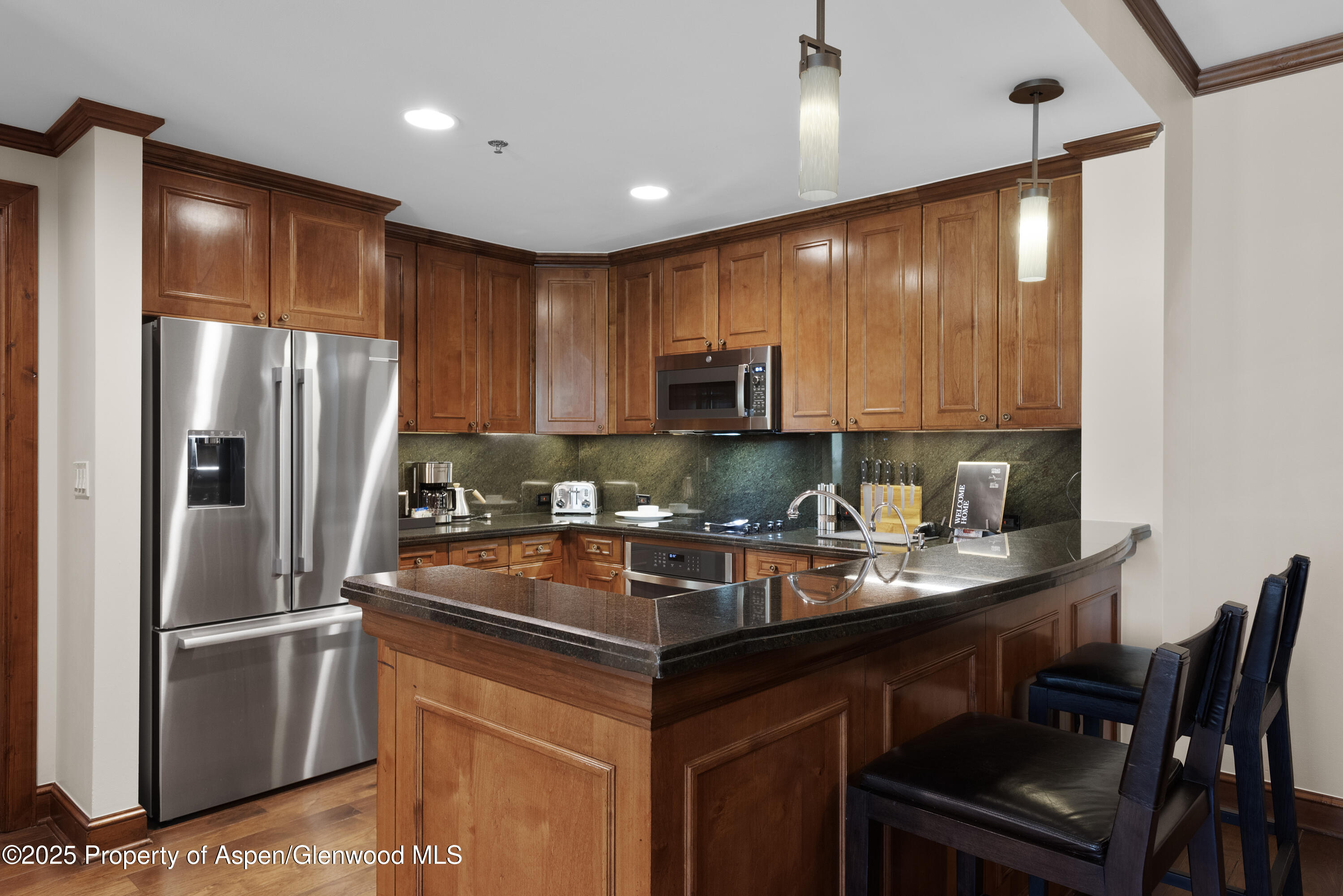39 Boomerang Road, Unit 8402/WINTER INTEREST 16 Aspen, CO 81611 - Photo 4 of 12 a kitchen with stainless steel appliances granite countertop a refrigerator a table and chairs