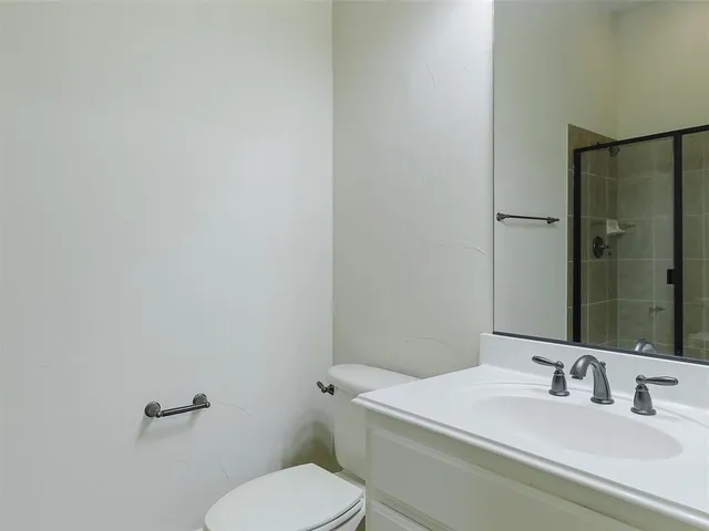 a bathroom with a granite countertop sink mirror vanity and toilet