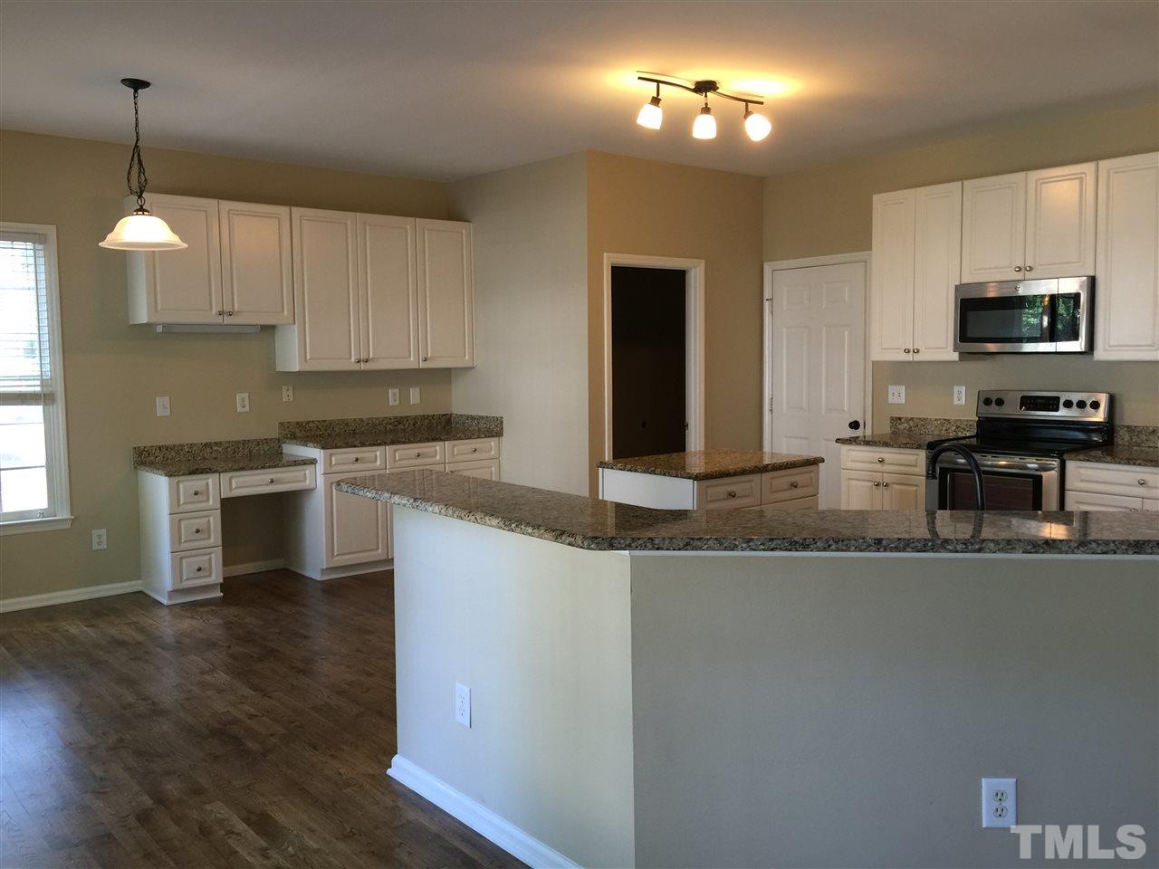 12109 Amoretto Way Raleigh, NC 27613 - Photo 2 of 8 a kitchen with stainless steel appliances granite countertop a sink a stove and a refrigerator