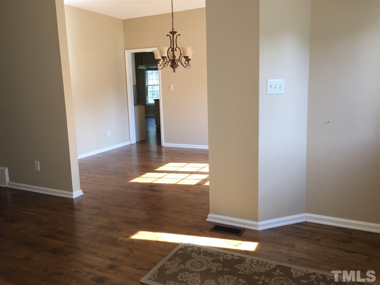 12109 Amoretto Way Raleigh, NC 27613 - Photo 4 of 8 an empty room with wooden floor and windows