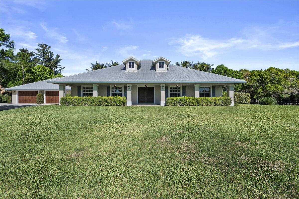 10975 Randolph Siding Road Jupiter, FL 33478 - Photo 8 of 97 a front view of a house with a garden