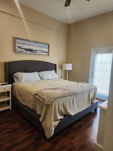 a bedroom with a bed and wooden floor