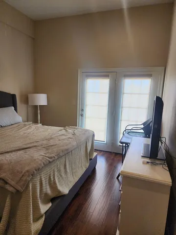 a bedroom with a bed and a mirror on the dresser
