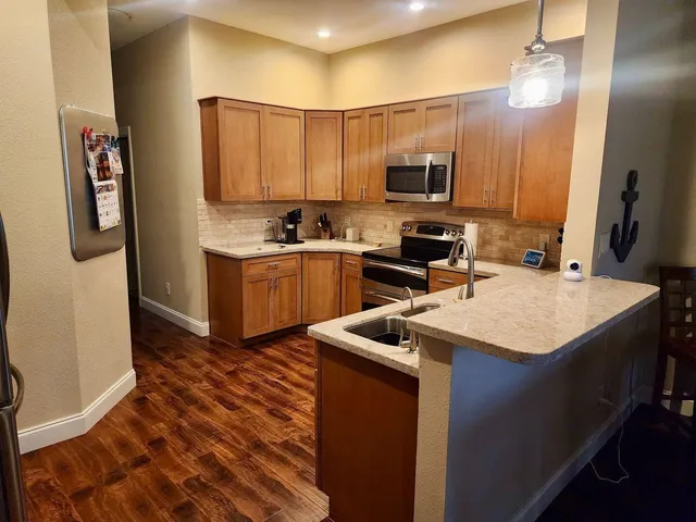 a kitchen with stainless steel appliances granite countertop a sink stove and refrigerator