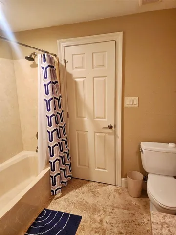 a bathroom with a toilet and a shower