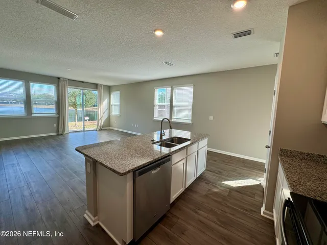 a kitchen with stainless steel appliances granite countertop a refrigerator stove top oven and sink