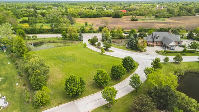 an aerial view of a house with a yard and lake view in back