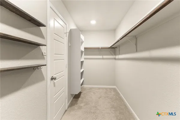 a view of walk in closet with empty racks