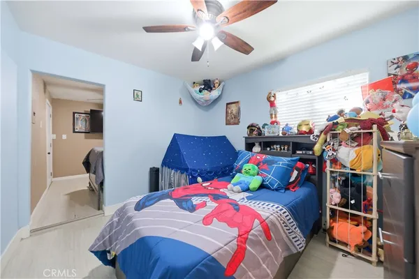 a spacious bedroom with a bed and a flat screen tv