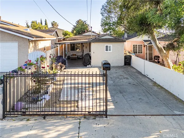 a view of a white house with large windows and a small yard