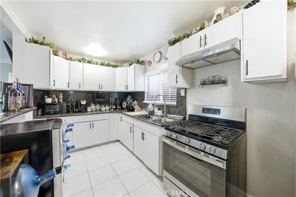a kitchen with granite countertop a stove sink and cabinets