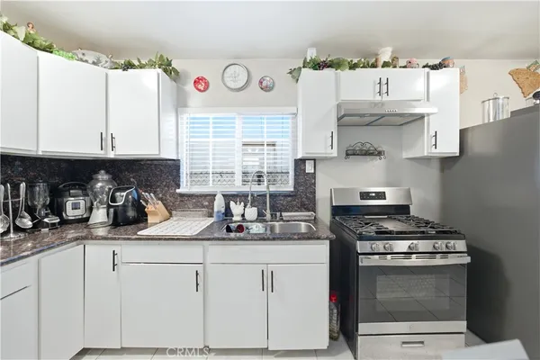 a kitchen with stainless steel appliances a stove a sink and a microwave