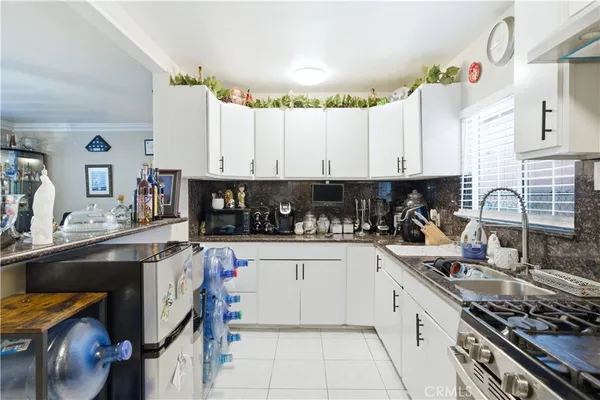 a kitchen with granite countertop a stove sink and cabinets