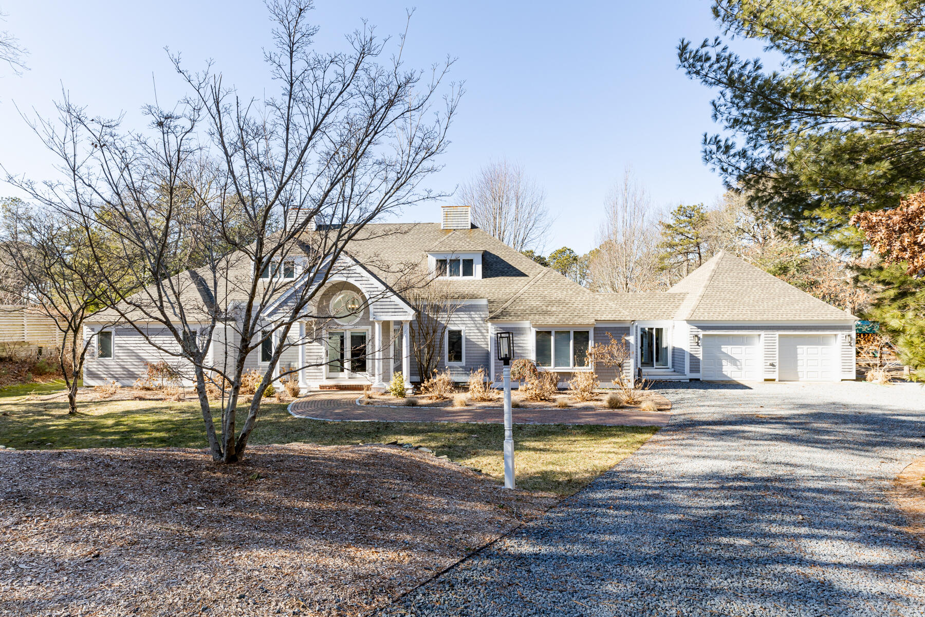 135 Paddock Circle Mashpee, MA 02649 - Photo 2 of 60 a front view of a house with garden and trees