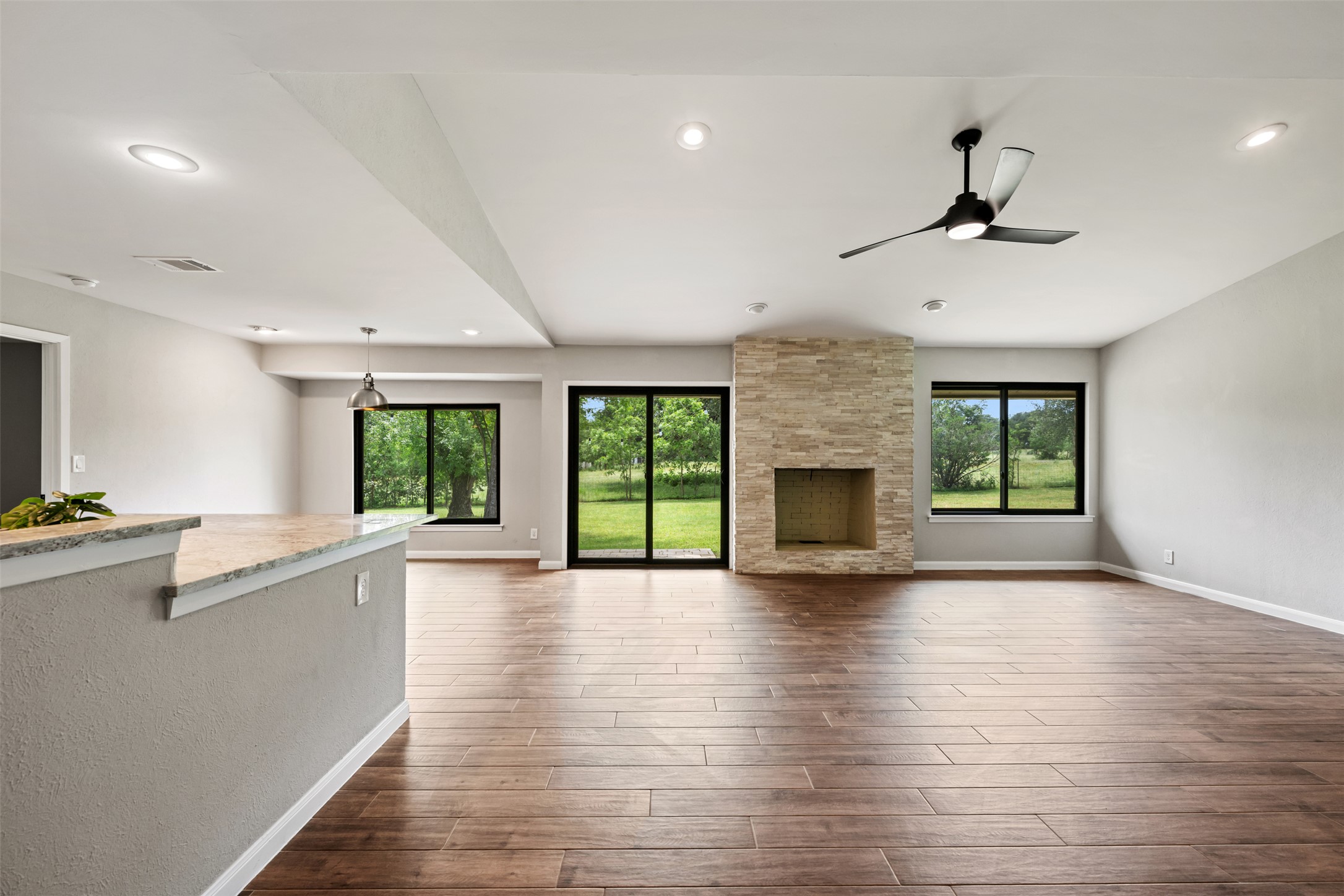 1600 Pin Oak Lane Round Rock, TX 78681 - Photo 11 of 40 Spacious living area featuring wood-finish flooring, a stacked stone fireplace, and ample recessed lighting