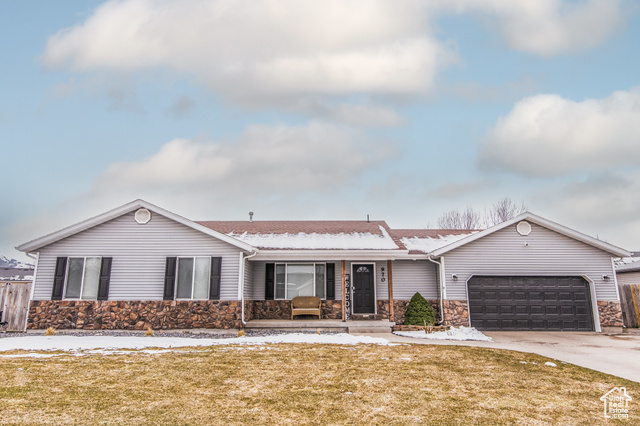 970 West 2770th Street South Logan, UT 84321 - Photo 1 of 1 Ranch-style house with a shingled roof, a lawn, a garage, stone siding, and driveway