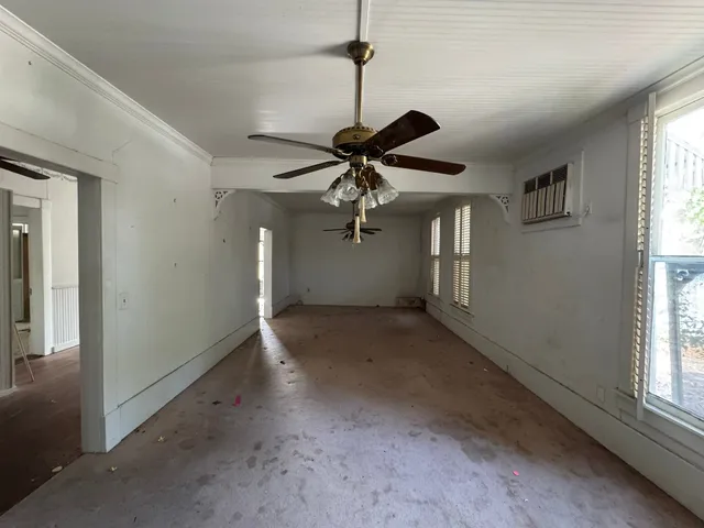 a large kitchen with a large counter top a sink stainless steel appliances and cabinets