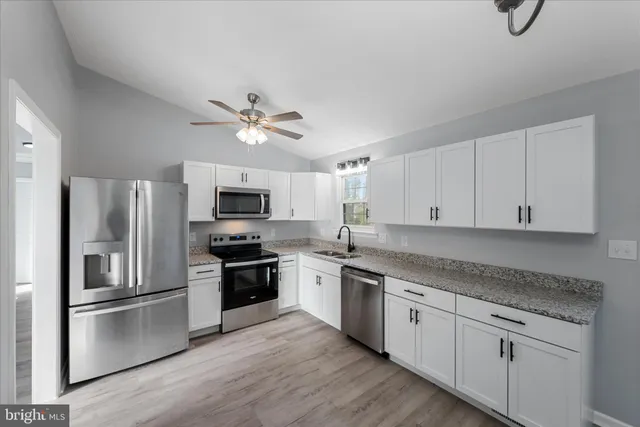 a kitchen with cabinets stainless steel appliances and a window