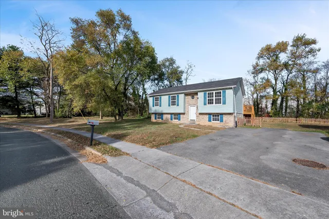 a view of a house with a yard and palm trees