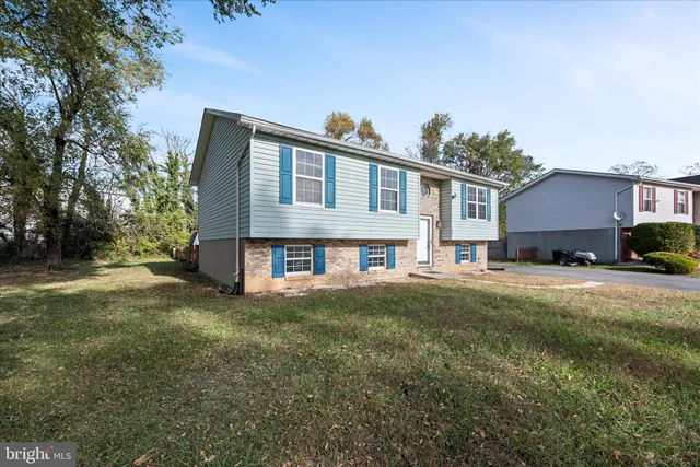 a front view of house with yard and trees in the background