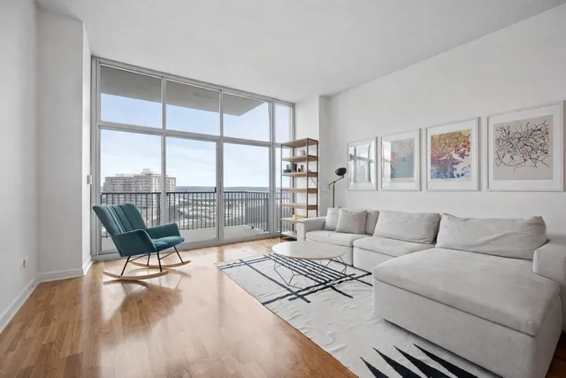 a living room with furniture and a floor to ceiling window