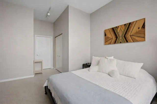 a bedroom with a bed and painting on the wall