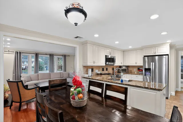 a view of a dining room with furniture a chandelier and wooden floor