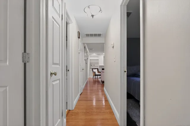 a view of a hallway with wooden floor and a living room
