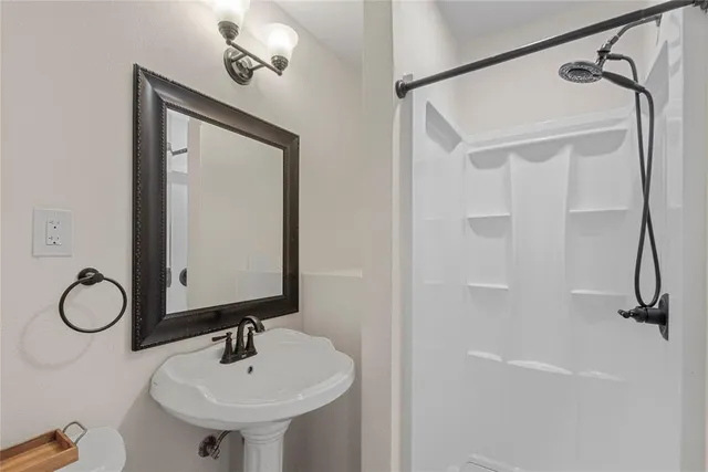 a bathroom with a sink toilet and a mirror