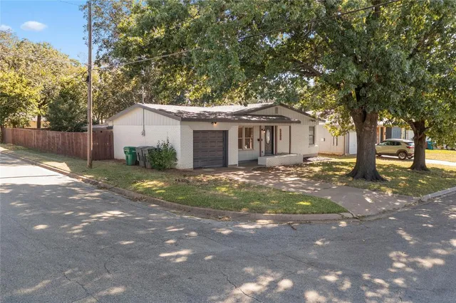 a front view of a house with a yard and trees
