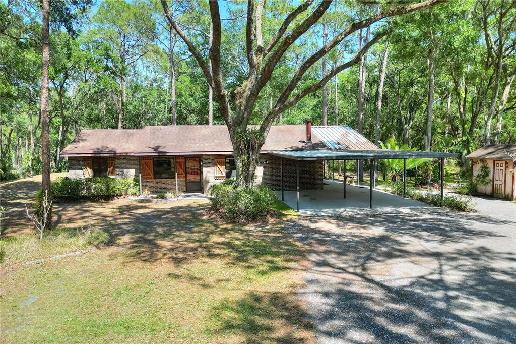 a view of a house with a yard and sitting area